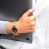 Wooden watch on wrist, holding laptop - website product