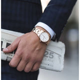Man in suit with gold watch and newspaper