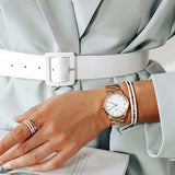 DW00100209 watch and jewelry set worn with a light green blazer.