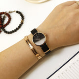 Black & gold watch and bracelet on wrist