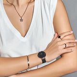 Woman wearing necklace, watch, bracelet & ring.