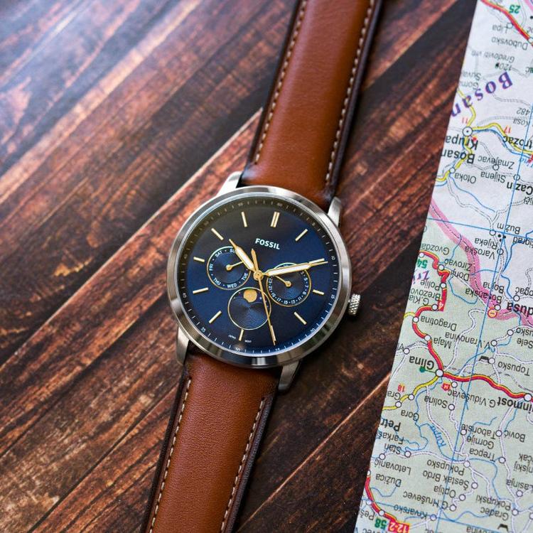 Fossil FS5903rr men's watch with blue face and brown leather strap, on a map.