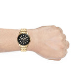 Gold Fossil watch on wrist