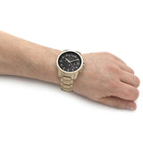 Armani Exchange men's gold watch with gray dial on wrist