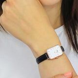 Woman wearing a square-faced watch.