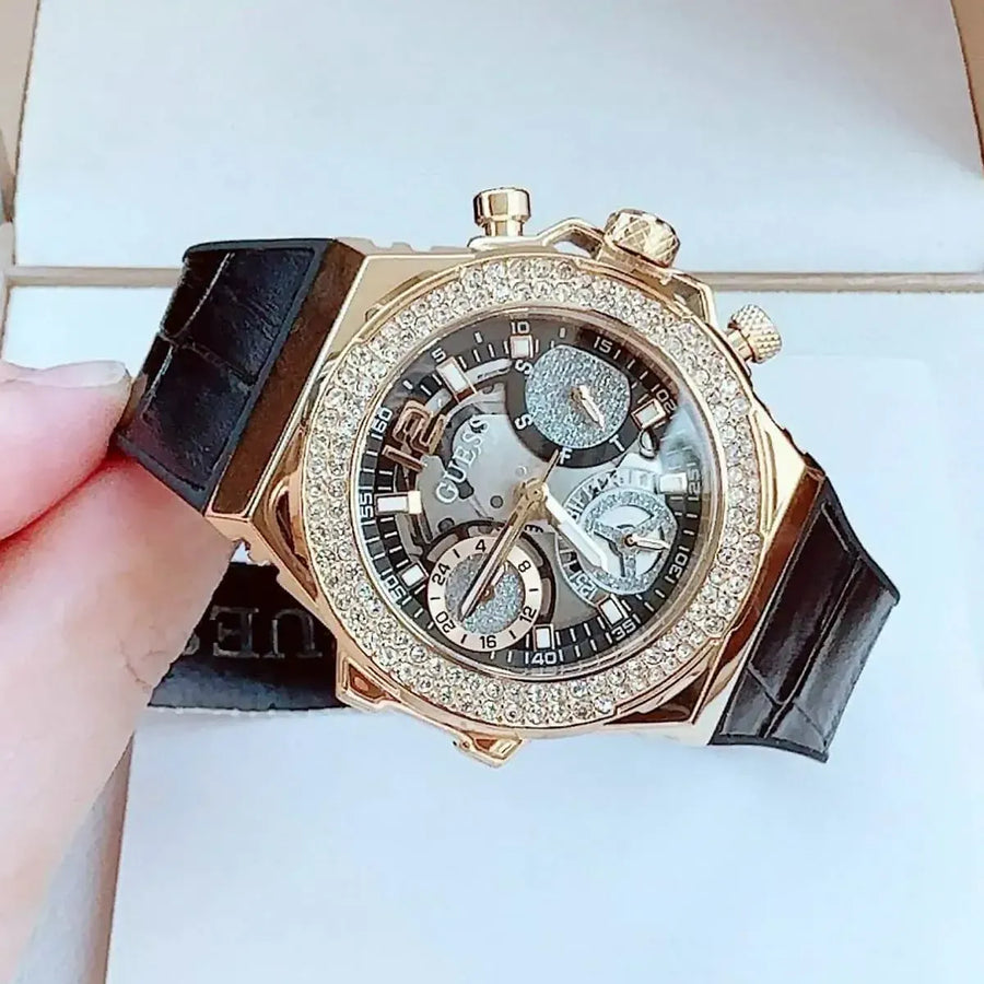 Guess women's watch with crystals, black dial, and leather strap.
