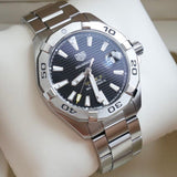 Tag Heuer Aquaracer watch with black face and silver band