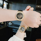 Gold Guess watches on wrists