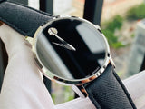 Movado watch with black face and leather strap.
